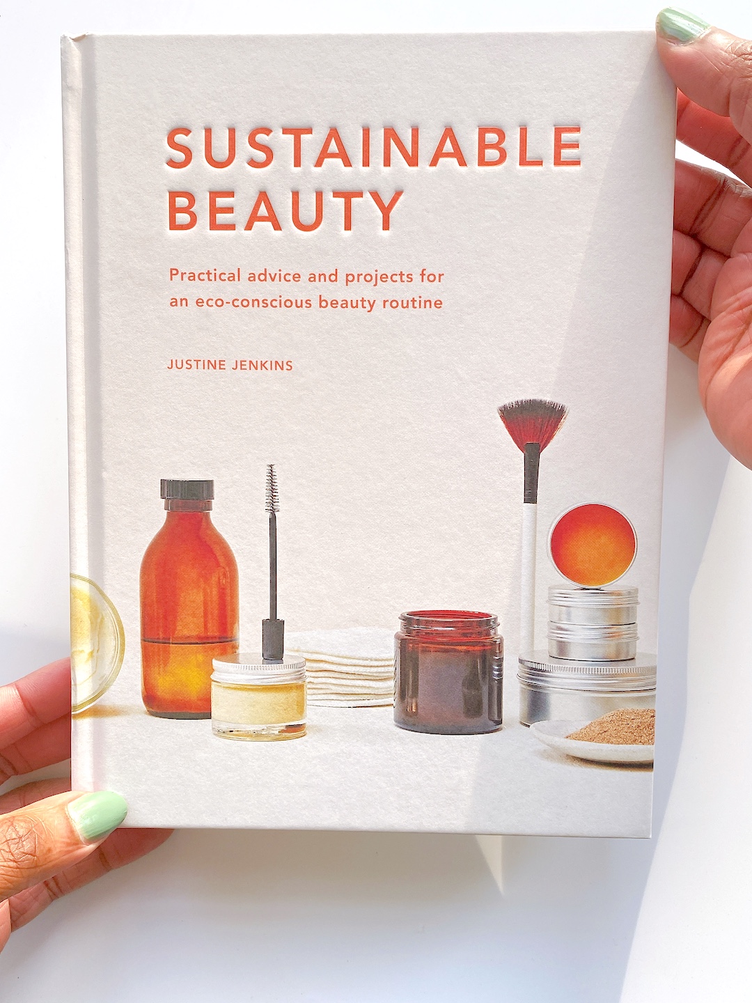 hand holding Sustainable Beauty by Justine Jenkins